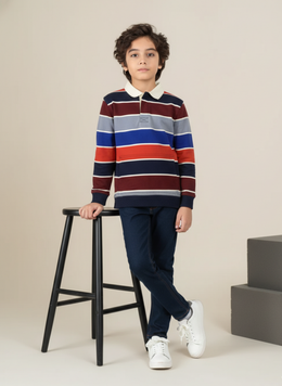 Child wearing a striped sweater and standing next to a stool on a plain background