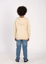 Person wearing a beige hoodie and blue jeans on a white background