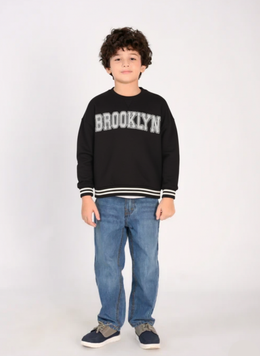 Child wearing a black sweatshirt with 'Brooklyn' text on a white background