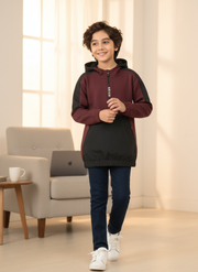 Child wearing a maroon and black hoodie in a living room setting