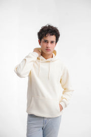 Person wearing a white hoodie and light blue jeans on a white background