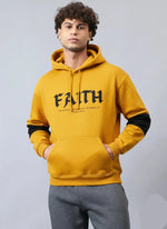 A man wearing mustard faith hoodie