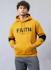 A man wearing mustard faith hoodie